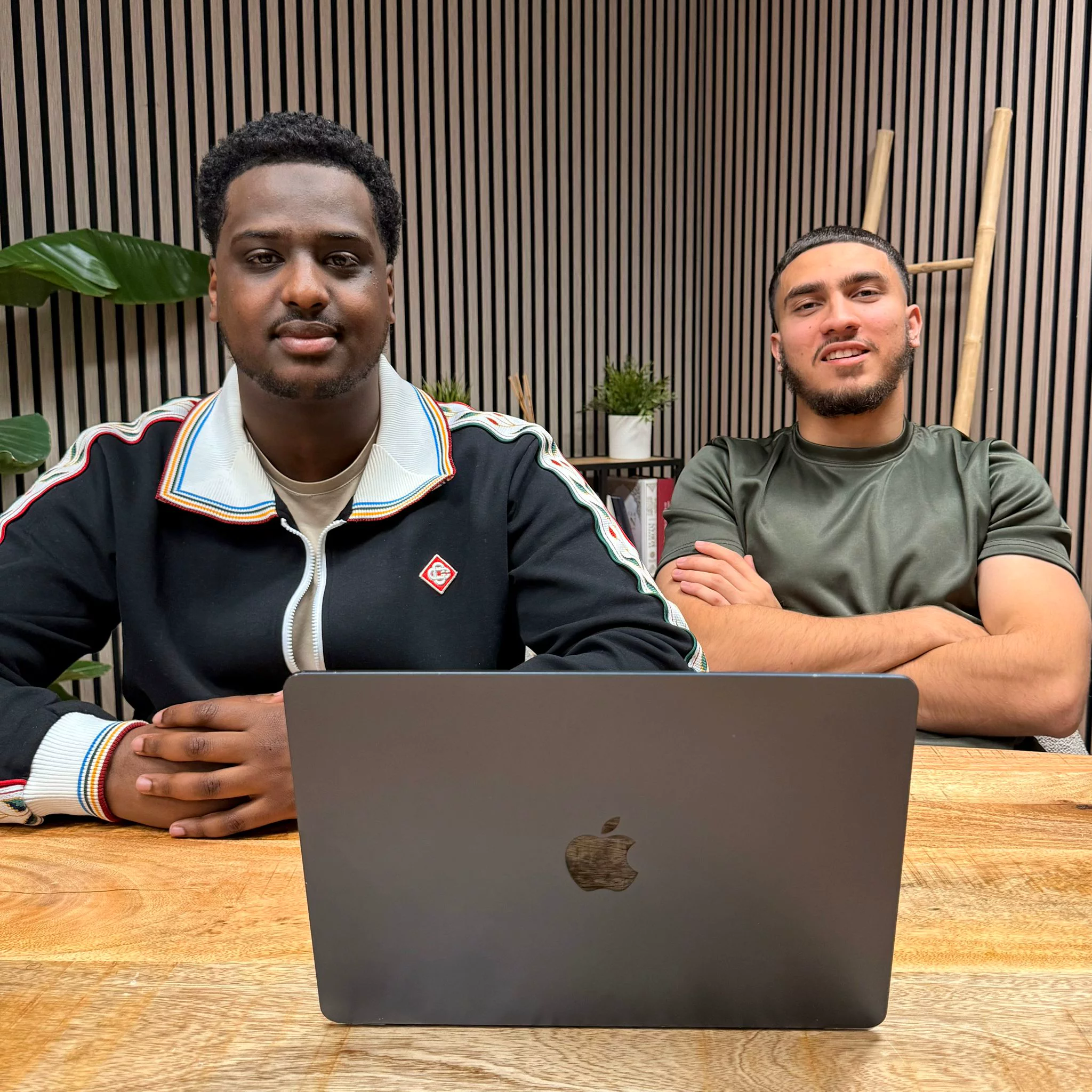 Het NIYA-team achter een echte MacBook tijdens een werksessie